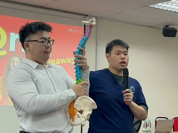 Persistence Chiropractic explaining the spine with a model at the Popular Bookstore health talk in Kuala Lumpur