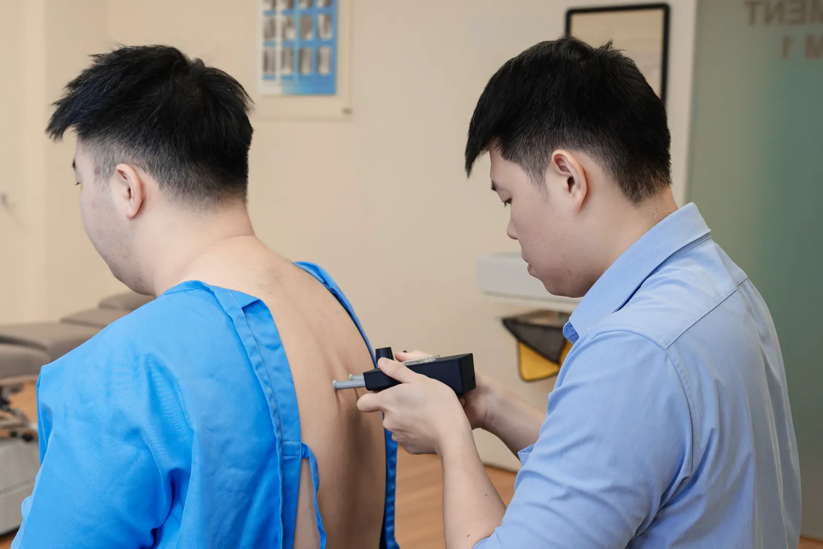 Gonstead chiropractor running a nervoscope along a patient spine during assessment in Cheras, Kuala Lumpur