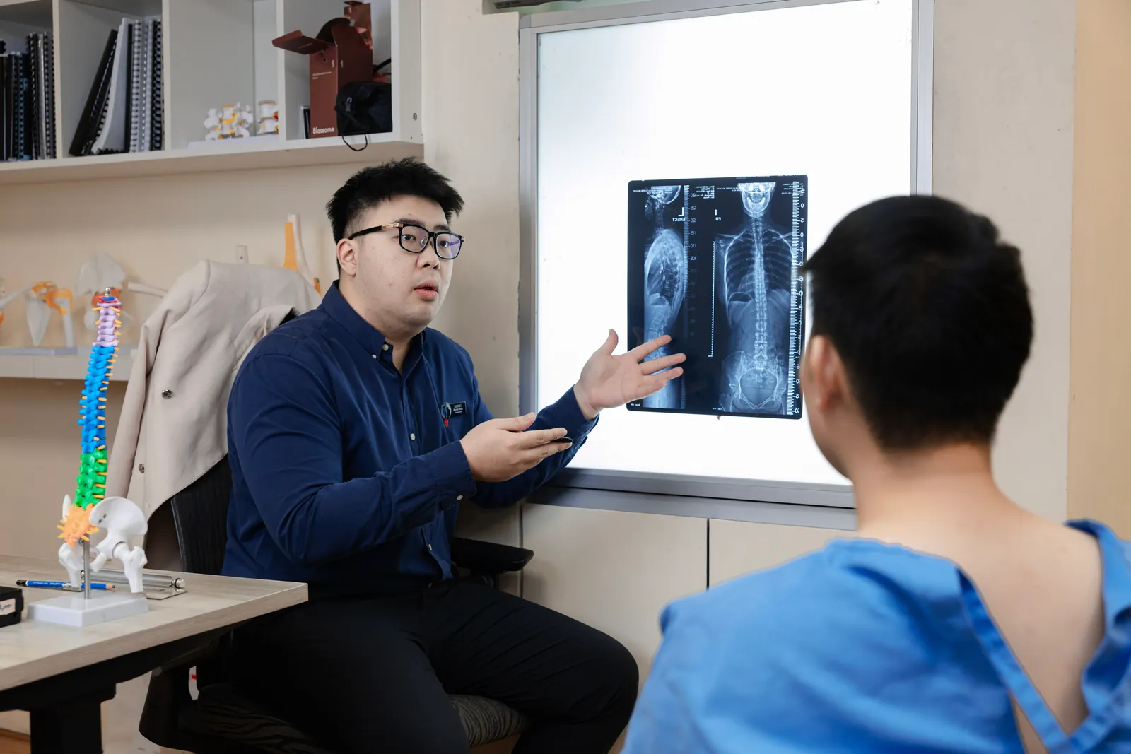 Chiropractor talking a patient through their spinal X-ray at Persistence Chiropractic Care in Cheras, Kuala Lumpur