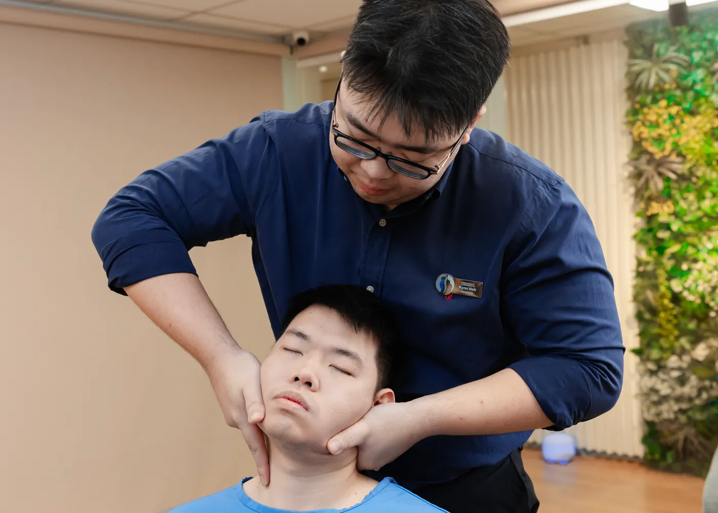 Physiotherapist working on a seated patient neck and shoulder at Persistence Chiropractic Care in Cheras, Kuala Lumpur